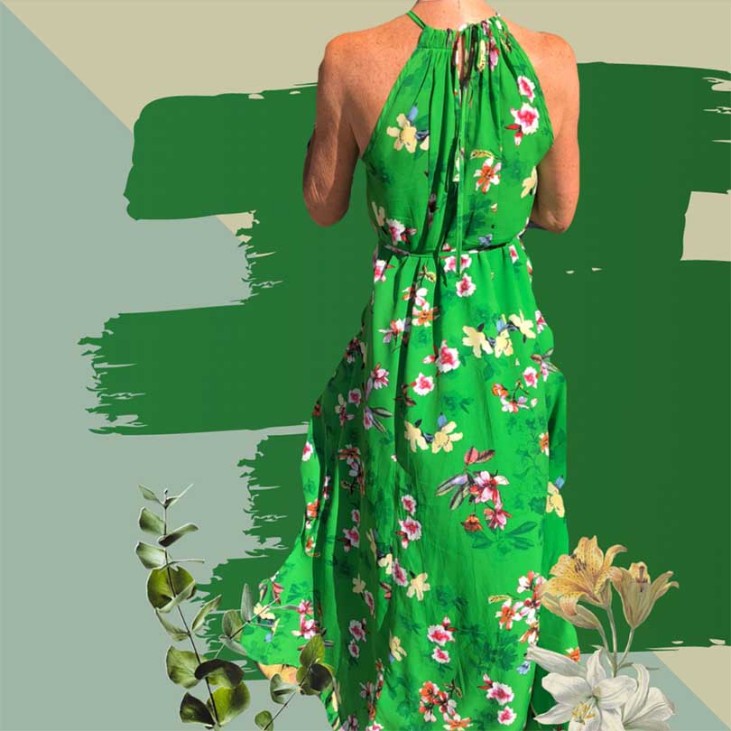 Model wearing green floral dress in front of painted wall